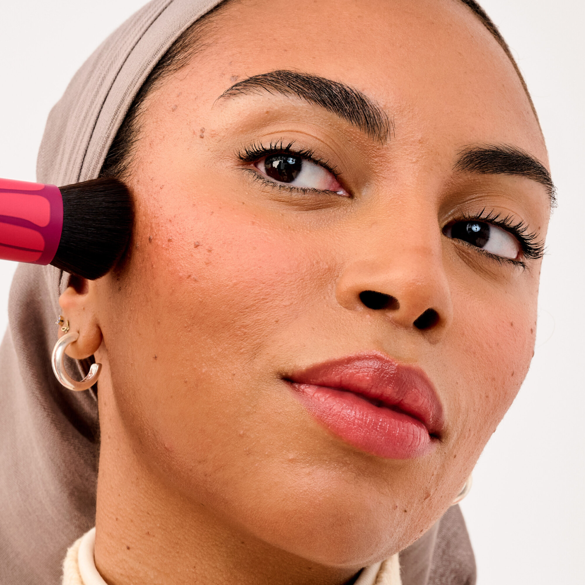 Trage deinen Bronzer in den Wangenknochenvertiefungen und entlang der Kieferkanten auf.