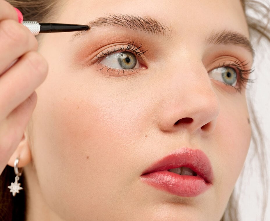 Model using eyebrow pencil