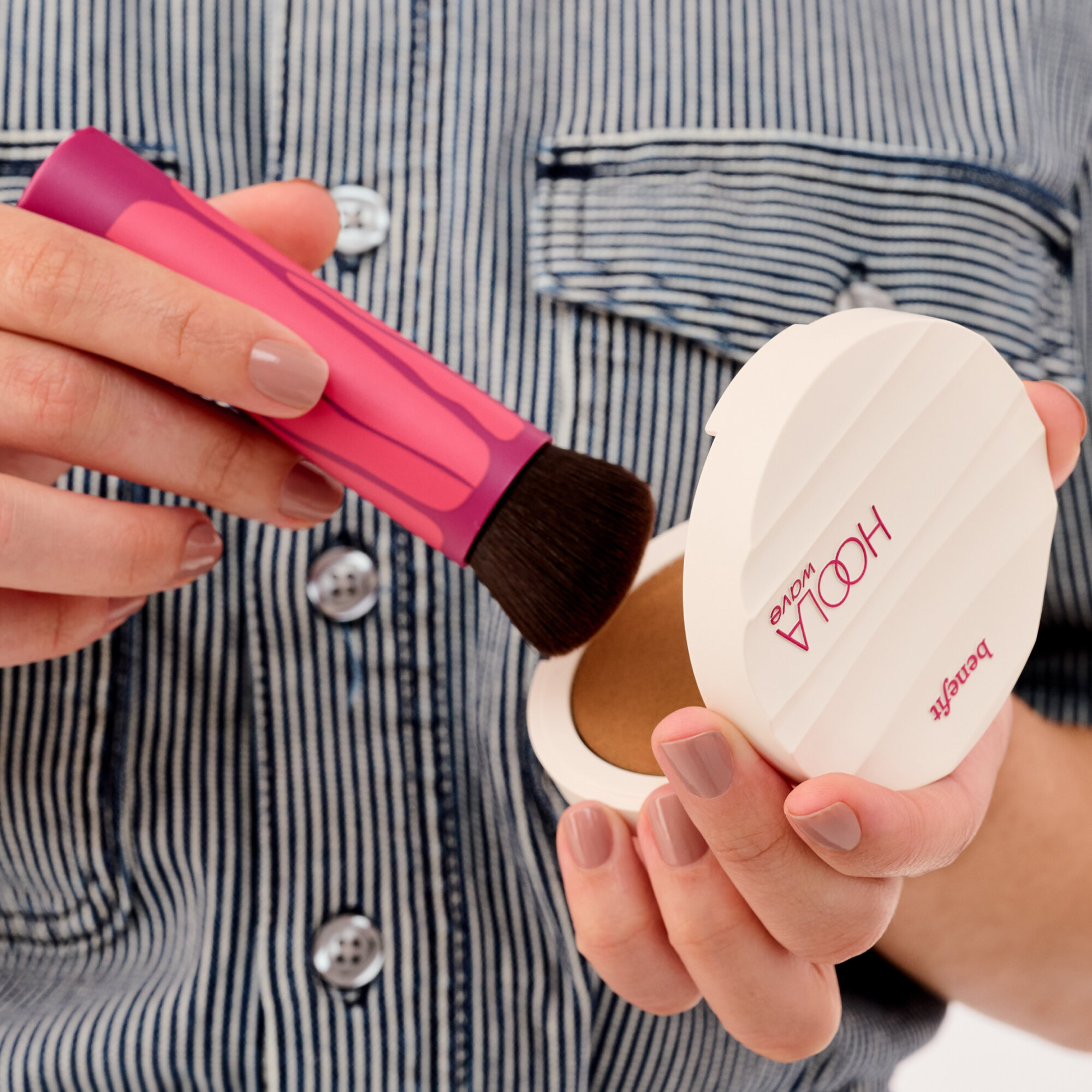 Model swirls brush in bronzing balm