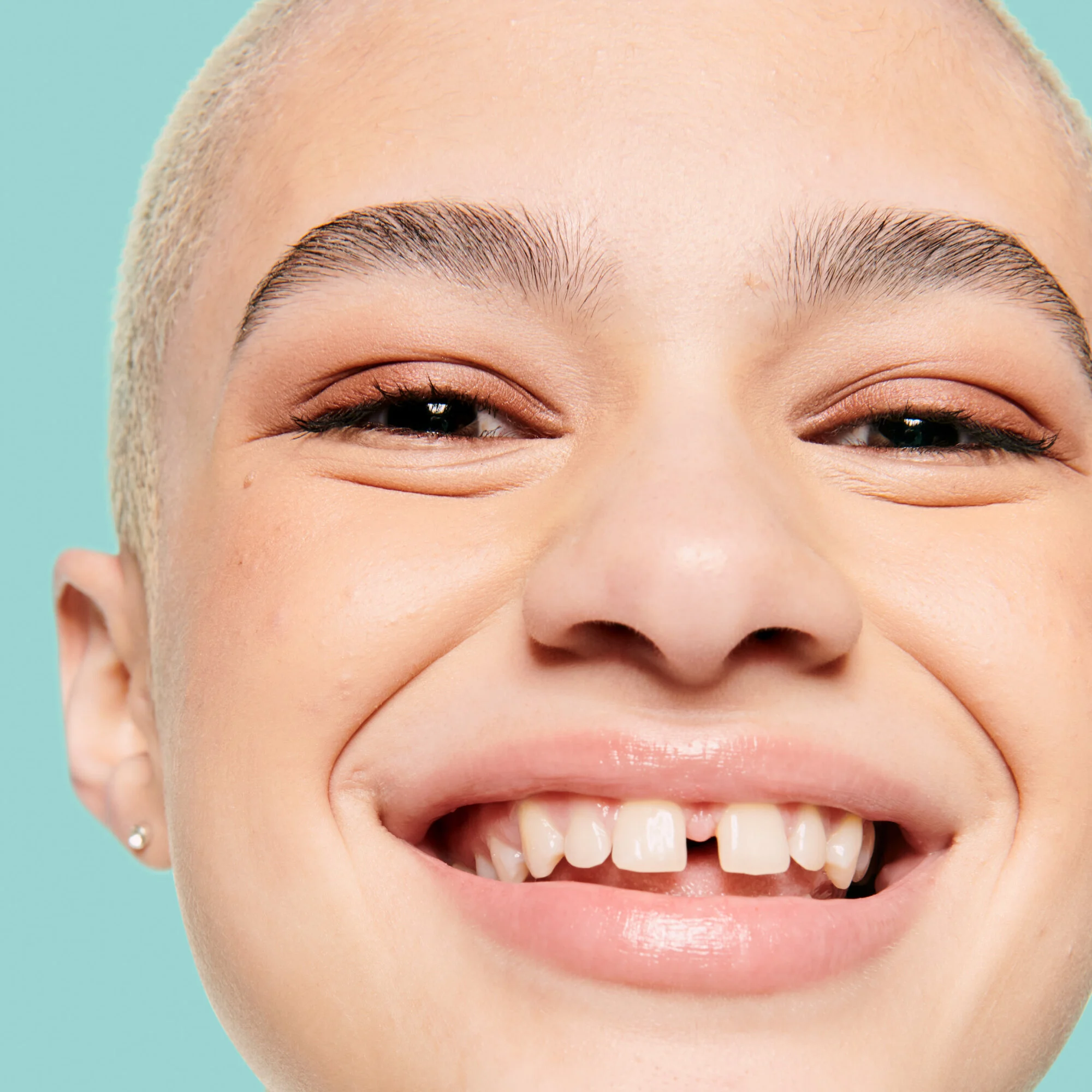 Verteile ihn mit den Fingerspitzen über das ganze Gesicht, um die Haut zu glätten und zu grundieren.